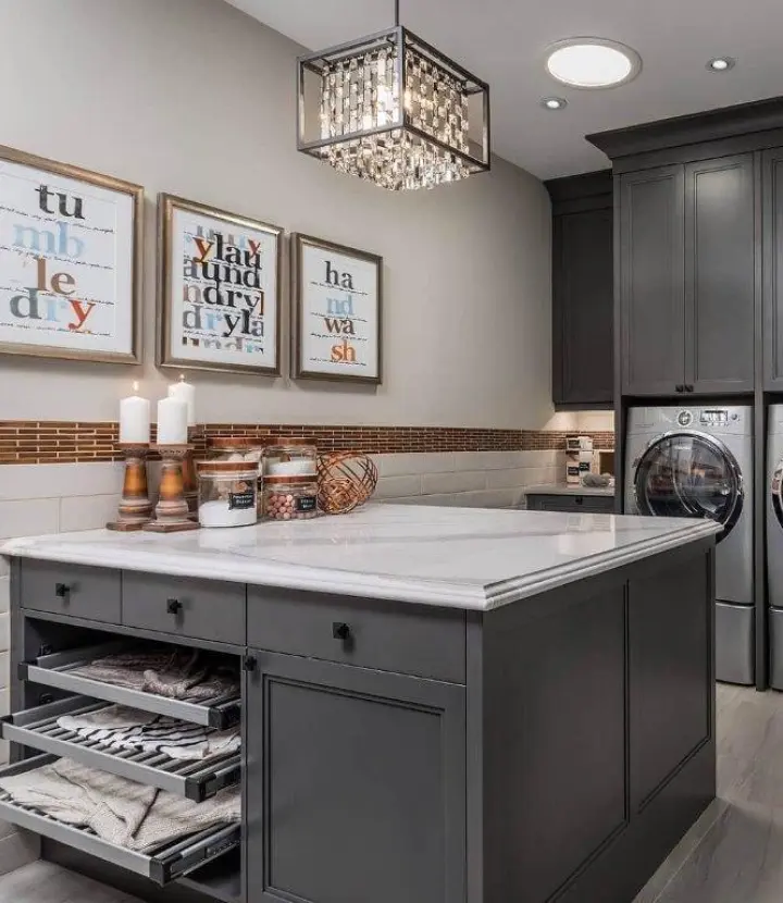 A kitchen with gray cabinets and white counter tops.