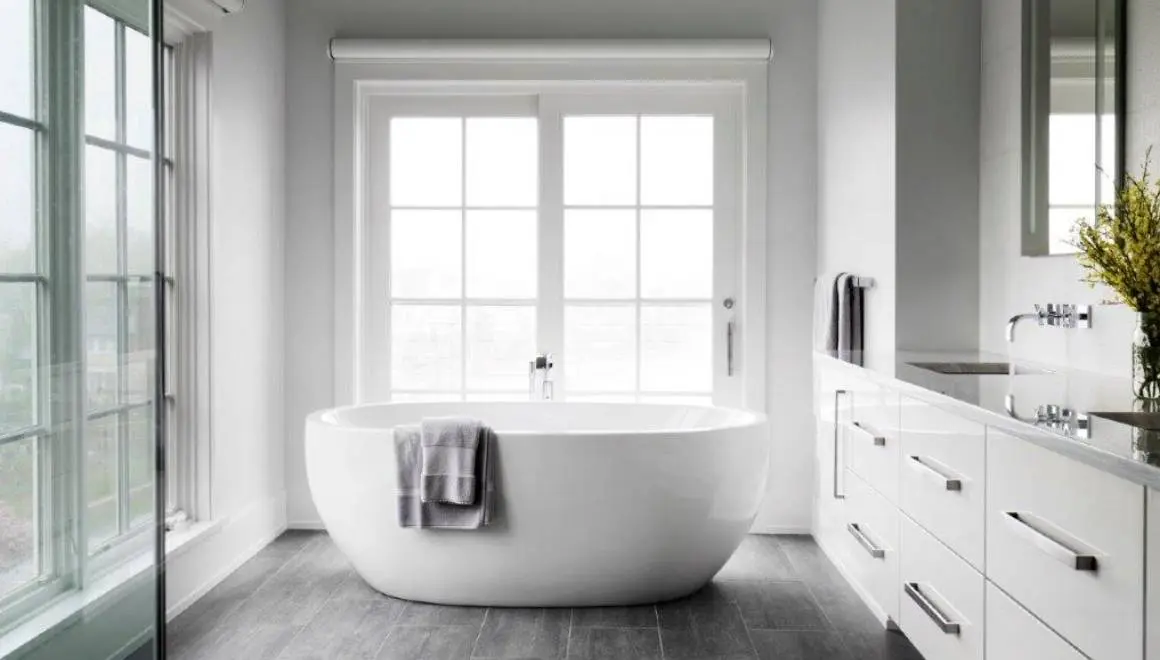 A white bath tub sitting in front of a window.