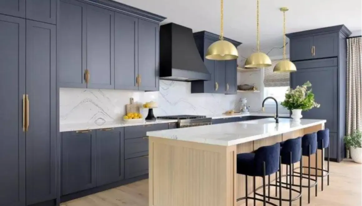 A kitchen with blue cabinets and gold fixtures.