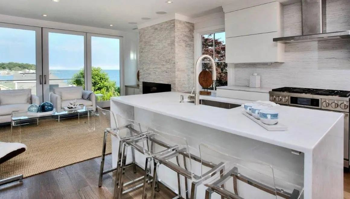 A kitchen with a sink and stools in it