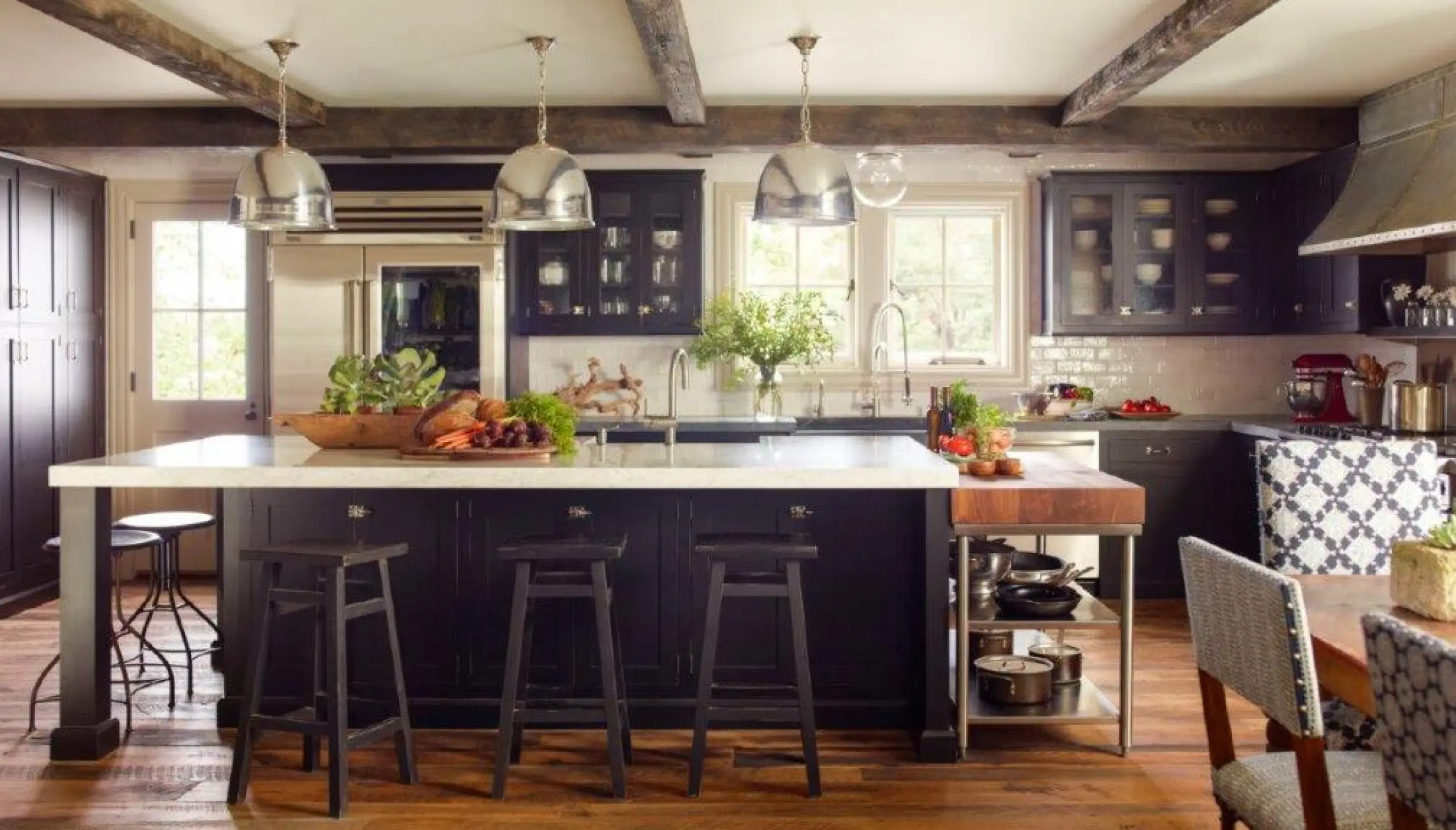 A kitchen with black cabinets and wooden floors.