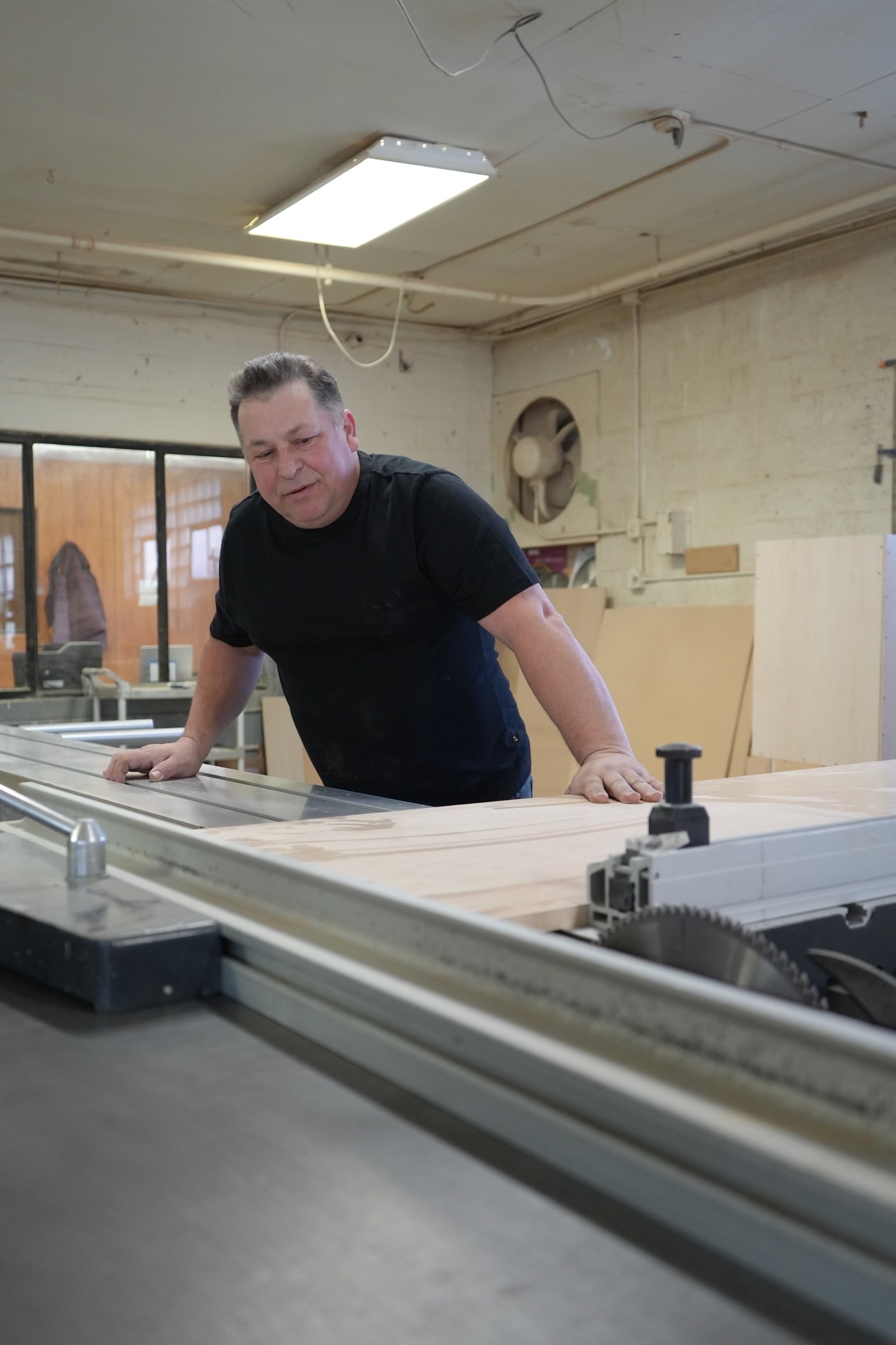 A man standing in front of a table saw.