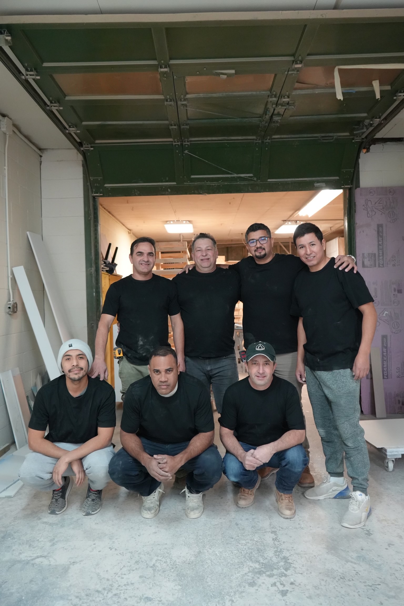 A group of men in black shirts and jeans.