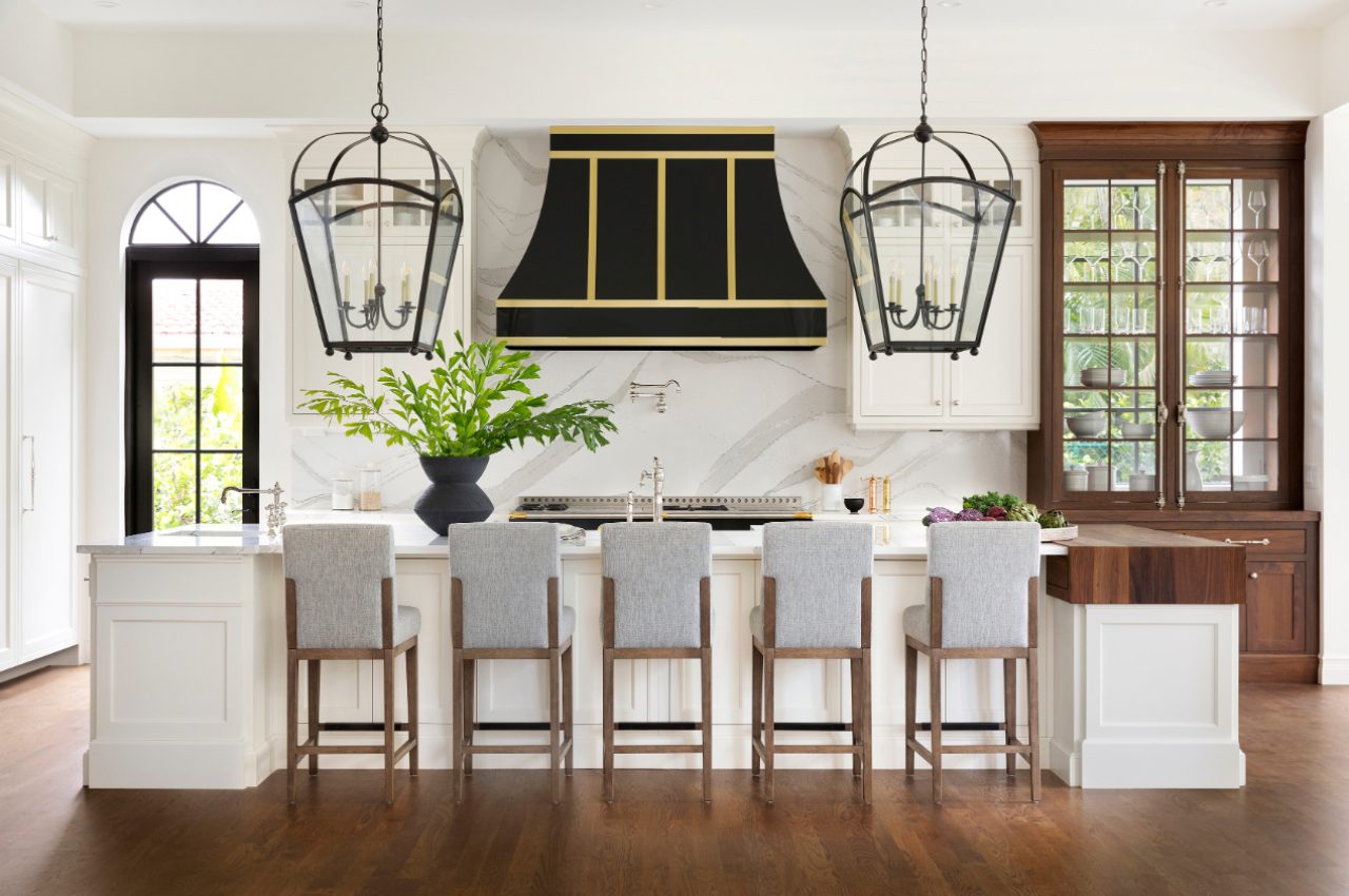 A kitchen with a large island and many chairs.