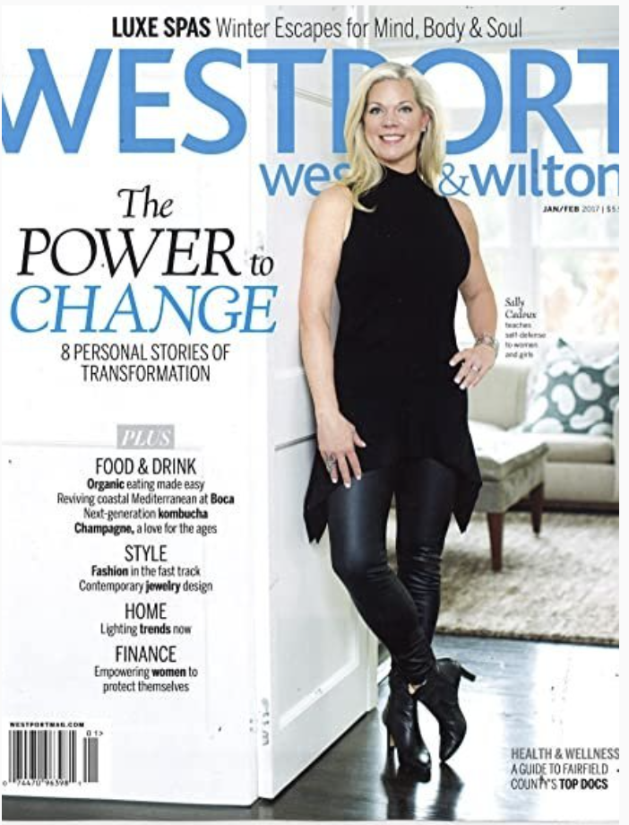 A woman standing in front of a wall with a magazine.